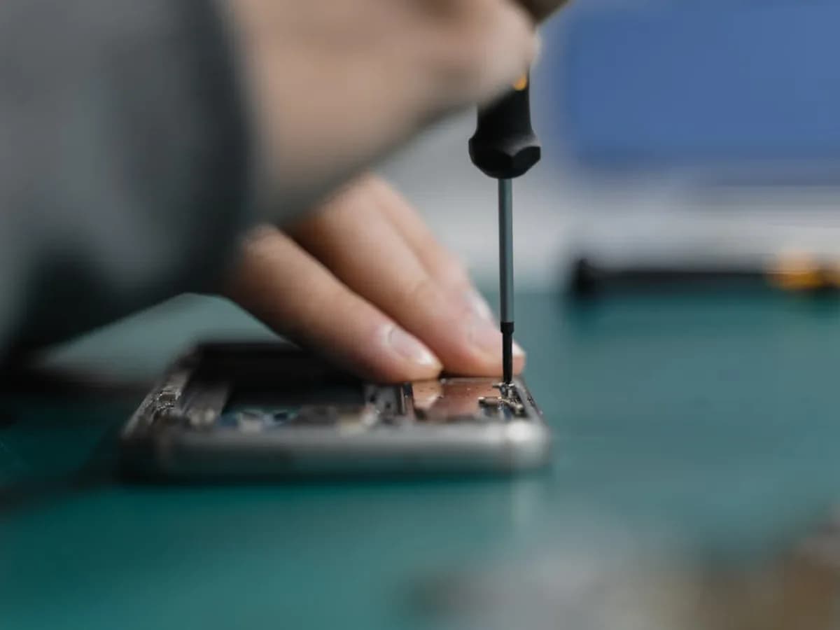 Technicien posant un film hydrogel sur un smartphone